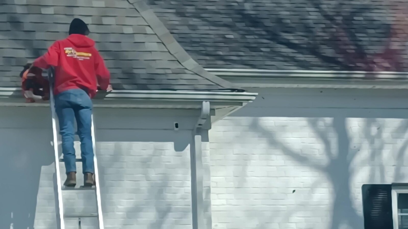 Heartland ProGutters technician removing loose gutter debris with a leaf blower