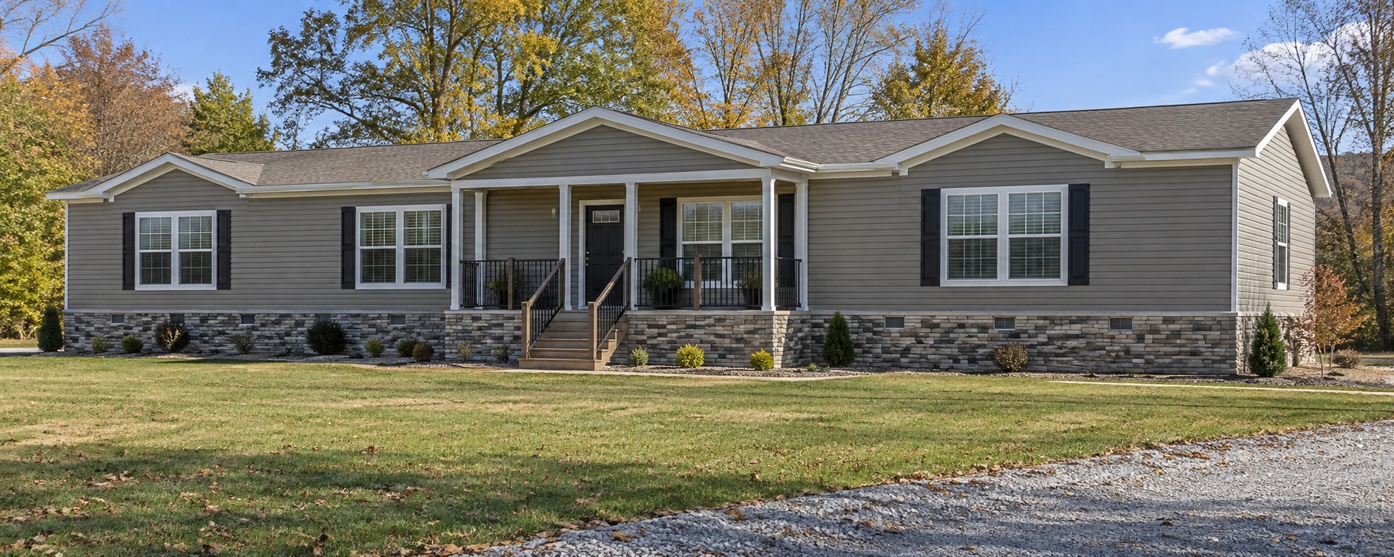 Illustrative higher-end triple-wide manufactured home with faux stone panel skirting