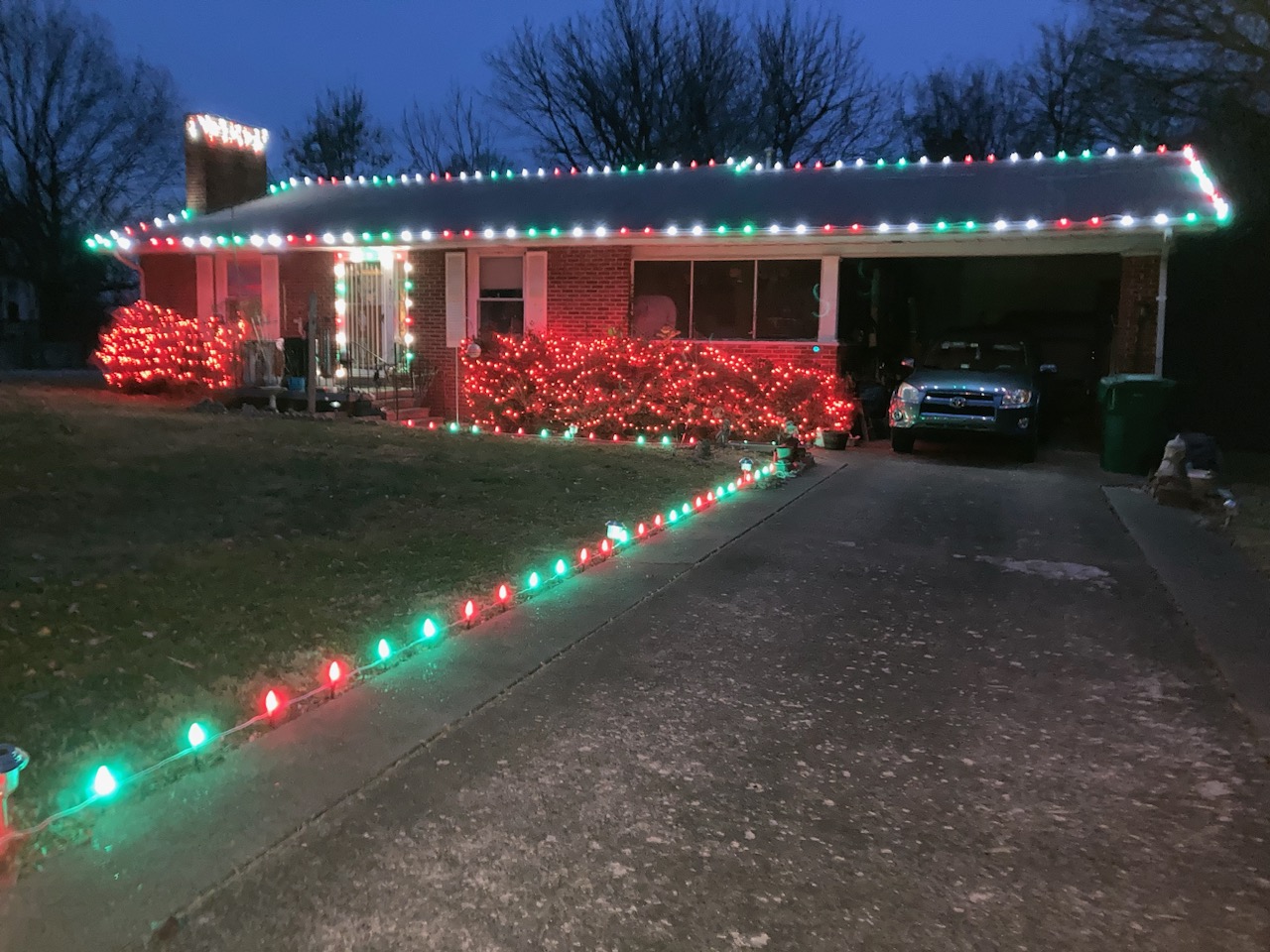 Wickliffe home decorated by Heartland ProGutters with red and green roofline, shrub and driveway lights
