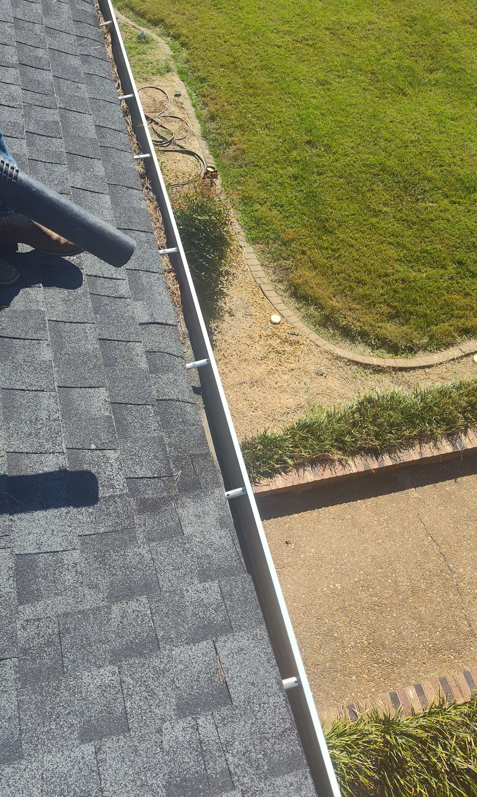 Crew member blowing loose debris out of a gutter, Kirbyton KY